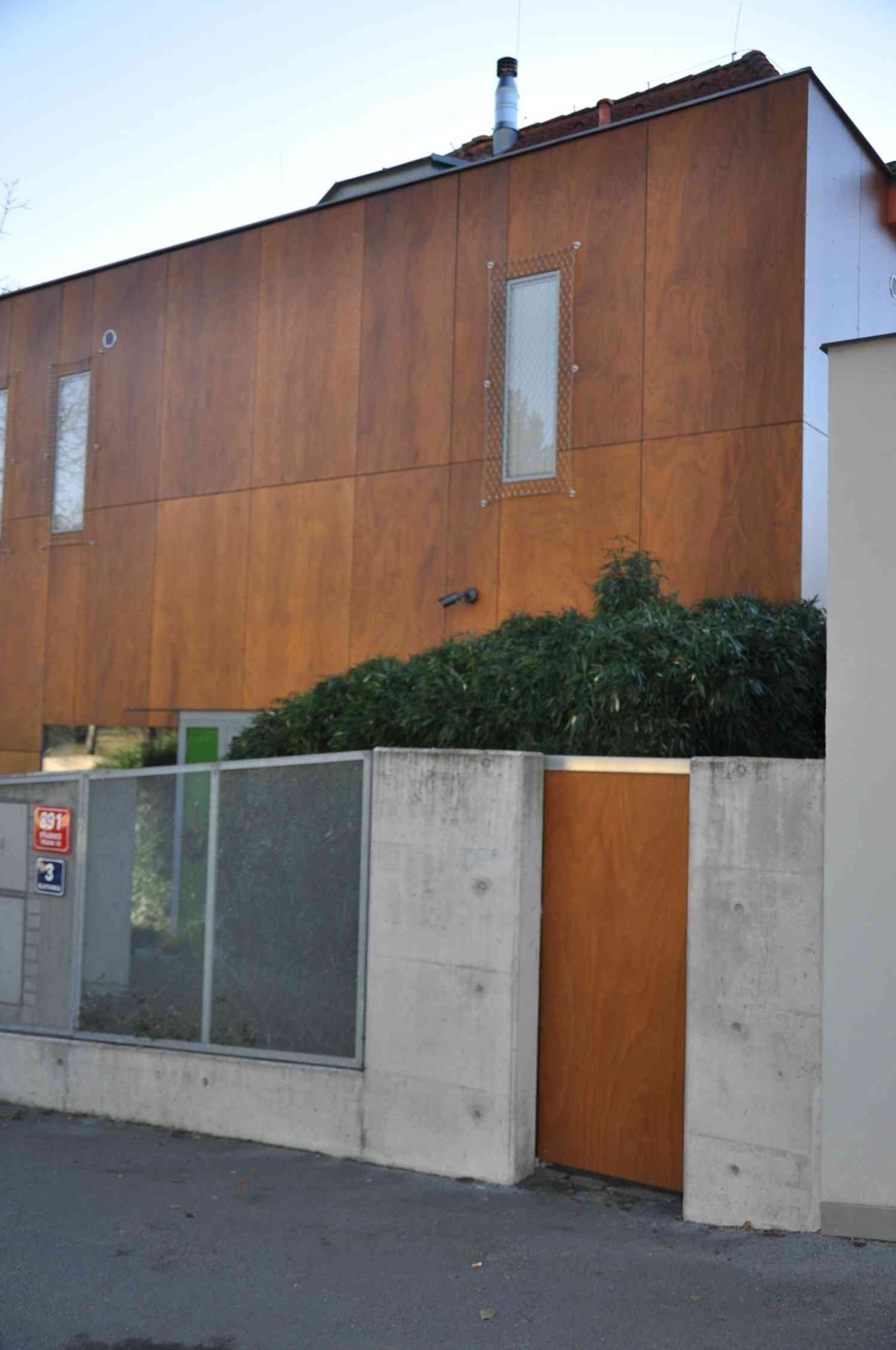 Exteriér budovy s fasádními panely imitujícími dřevo